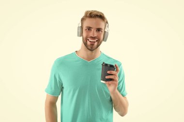 Arkaplanda kulaklık takan olumlu adam milenyumu. Stüdyoda milenyum kulaklıklı bir adam. Kulaklıkla milenyum fotoğrafı. Bin yıllık kulaklıklı bir adam beyazlara izole edilmiş..