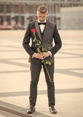 elegant man bridegroom in tuxedo. bridegroom in tuxedo bowtie outdoor. handsome bridegroom with red rose.