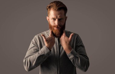 İrlandalı adam sakala dokunuyor. Sakallı ve bıyıklı, şık bir adam. Yakışıklı traşsız adam stüdyosu Grey 'de izole edilmiş..