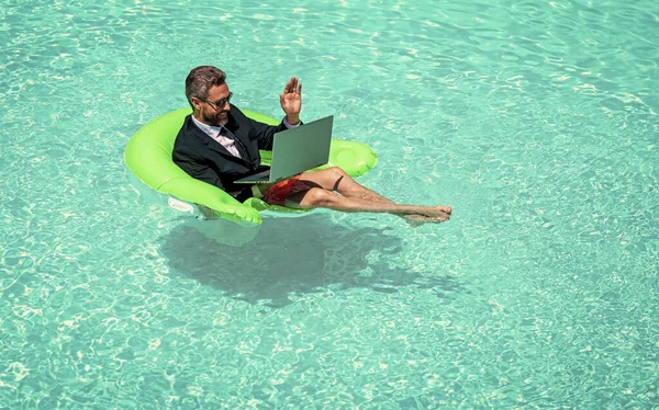 man has business video conference with laptop, copy space. photo of man has business video conference. man has business video conference. man has business video conference refreshing at pool.