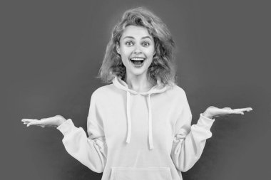 Stüdyoda şık bir kadın, reklam. Kapüşonlu şık bir kadının fotoğrafı. Renkli, kızıl saçlı bir kadın. Kırmızı arka planda izole edilmiş şık bir kadın..