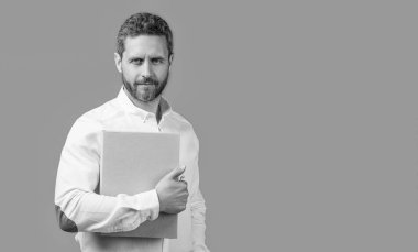 İşadamı elinde dizüstü bilgisayar ve pankart tutuyor. İşadamı, mavi arka planda izole edilmiş. Stüdyoda serbest çalışan bir iş adamı. Bilgisayarlı işadamı serbest.