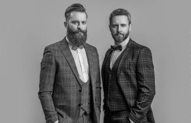 Smokinli papyonlu adamlar Griler 'de izole edilmiş. Smokinli adamlar stüdyoda. Smokinli adamlar arka planda. Smokinli adamların fotoğrafı..