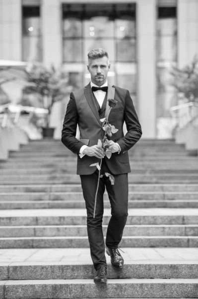 在特殊场合穿正装 优雅的男人 带着玫瑰参加特别的场合 晚礼服男人在特殊场合外出散步 — 图库照片