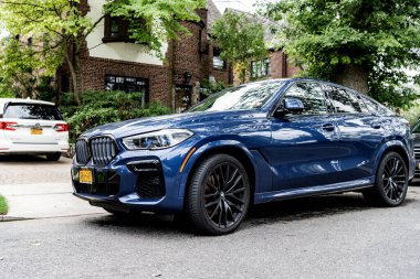 New York City, ABD - 26 Ağustos 2023: BMW X6 SUV mavi renk, köşe kenarı manzaralı.