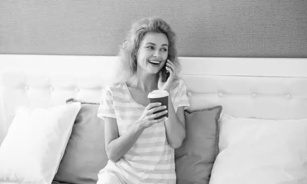 woman laugh with coffee talk on phone. woman at home talking on phone. phone talk at home of woman.