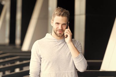 Gülümseyen adam akıllı telefondan konuşuyor. Adam sokakta akıllı telefonlardan konuşuyor. Adam dışarıda akıllı telefonlardan konuşuyor. Akıllı telefondan konuşan adamın fotoğrafı..