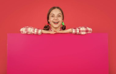 Reklam için fotokopi alanı olan boş pembe kağıtlı mutlu çocuk..