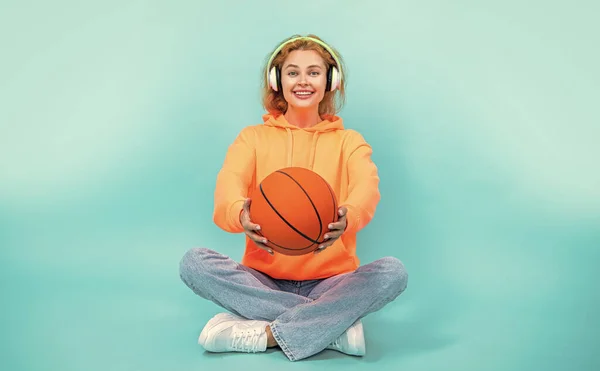 selective focus photo of basketball woman loves music isolated on blue.