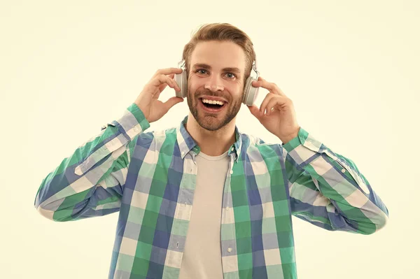 smiling millennial man wear music headphones in studio. millennial man listening music on background. photo of millennial man music lover. millennial man listen music isolated on white.