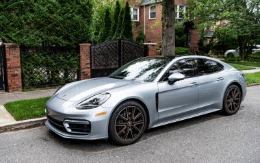New York City, ABD - 26 Ağustos 2023: Porsche Panamera spor araba gümüş rengi park edilmiş, yan görüş.