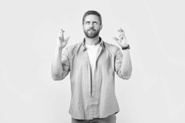 Dilek tutan adam gri arka planda dilek tutar. Dilek tutan adam stüdyoda dilek diler. Dilek tutan adamın fotoğrafı. Dilek tutan adam parmak kaldırarak dilek tutar..