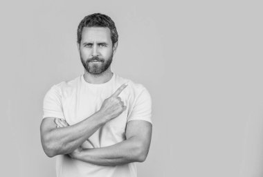 Reklam teklifini gösteren adamın fotoğrafı, fotokopi alanı. Reklam teklifine işaret eden adam sarı üzerine izole edilmiş. Adam arka plandaki reklam teklifini işaret ediyor. Adam reklam teklifini işaret ediyor.