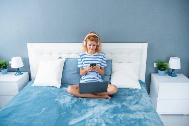 Telefonda gülümseyen kız sohbeti. Evde telefonla konuşan bir kız. Kulaklıklı kızın telefon konuşması..