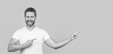 Stüdyoda sıradan bir yönetmen. Beyaz gömlek giyen beyaz bir adamın fotoğrafı. Sıradan giyinen bir adam. Sıradan gömlekli sakallı adam sarı arka planda izole edilmiş..