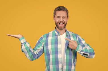 Sıradan giyinmiş, yönetmenlik yapan beyaz bir adam. Sarı arka planda, günlük gömlekli, sakallı, beyaz bir adam. Stüdyoda sıradan bir beyaz adam var. Beyaz adamın fotoğrafı. Kareli gömlek giy..