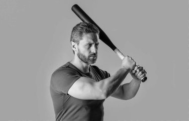 Kızgın adamın sopayla vurduğu fotoğraf. Kızgın adam tehdit ediyor. Öfkeli adam, gri arka planda izole edilmiş yarasayla öfkesini ifade eder. Stüdyoda sopalı kızgın adamın saldırganlığı..