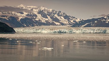 Karlı dağ buzlu zirveleri. Hubbard Buzulu doğası Alaska, ABD. Dağ buzulu yavrusu ve deniz suyu manzarasında buz. Dağ kıyısı doğal manzarası. Buzul Körfezi Doğası.