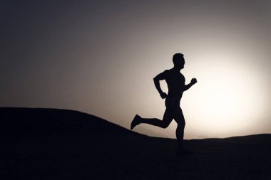 siluet günbatımı arka plan, genç Kafkas dağ içinde çalıştırmak üzerinde koşan adam