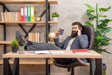 Mutlu müdür rahat rahat telefonda konuşuyor ve ofiste kahve içiyor, mola veriyor..