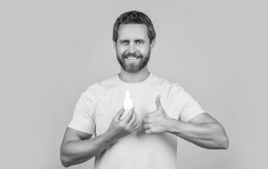 Sağlık sigortası uzmanı arka planda, başparmağını kaldır. Stüdyoda tıbbı olan bir sağlık görevlisi. İlaç damlalı bir sağlık görevlisinin fotoğrafı. Sağlık hizmetleri görevlisi sarıda izole edilmiş..