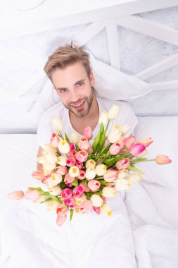 Kadınlar günü çiçekleri olan neşeli romantik bir adam. Kadınlar günü çiçekleri olan bir erkek. Kadınlar günü çiçek buketi olan bir adamın fotoğrafı. Kadınlar günü çiçekli bir erkek..