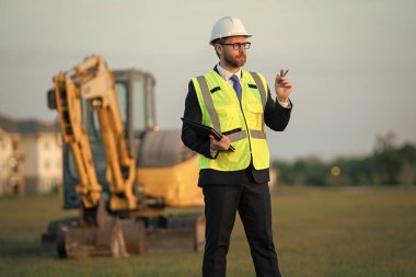 İnşaat alanındaki amir. Dışarıdaki denetçi. Kask takan amir. Yönetici adamın fotoğrafı.