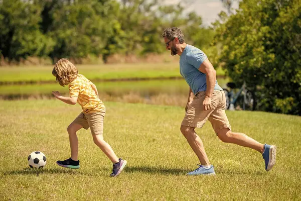 adventures between father and son. Active father son playing football in summer. Father and child son teaming up outdoor. Father dad and son enjoying outdoor activities together. having fun together.