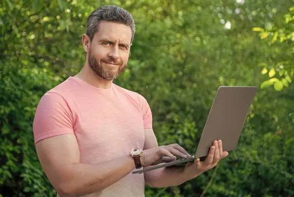 happy man has business online on laptop. photo of man has business online. man has business online. man has business online outdoor.