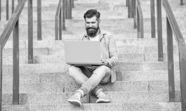 Gülümseyen adamın merdivenlerde otururken çevrimiçi video bağlantısı var. Adamın bilgisayarında çevrimiçi video bağlantısı var. Adamın dışarıda online video iletişimi var. Adamın dışarıda internet bağlantısı var..