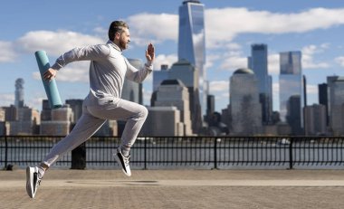 Manhattan 'da koşan adam. New York 'ta sabah sporu koşucusu. Spor antrenmanında koşan koşucu. Sporcu koşucu ya da koşucu. Spor takım elbiseli bir adam koşu yapıyor. Reklam..