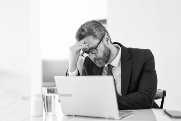 stock image overworked man manager has pain and fatigue. photo of man manager has pain and fatigue. man manager has pain and fatigue in office. man manager has pain and fatigue while working.