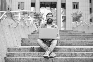 Gülen serbest çalışan adamın dizüstü bilgisayarında iletişimi var. Serbest çalışan adamın dışarıdaki bilgisayarla iletişimi var. Dışarıdaki serbest çalışan adamın iletişimi. Serbest çalışan adamın kahve molasında iletişimi var..