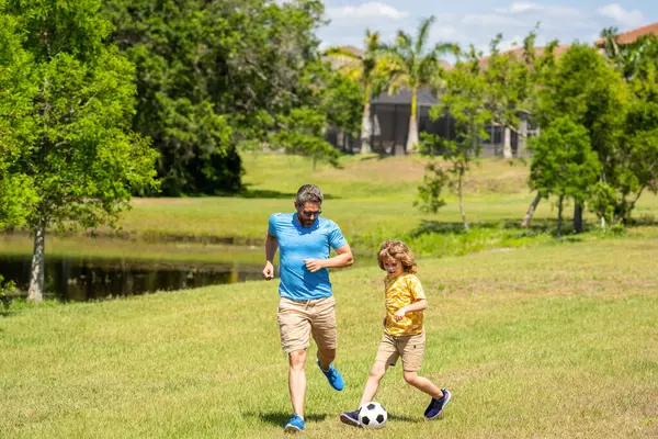 adventures between father and son. Active father son playing football in summer. Father and child son teaming up outdoor. Father dad and son enjoying outdoor activities together. summer park together.