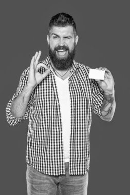 Neşeli sakallı adam, kopyalama alanı olan boş bir banka kartı gösteriyor.