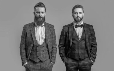 Smokinli adamların fotoğrafı. Smokinli adamlar Griler 'de izole edilmiş. Smokinli adamlar stüdyoda. Smokinli adamlar arka planda.