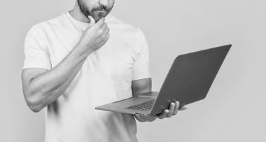 Arka planda serbest çalışan bir adam. Kesik manzaralı. Stüdyoda serbest çalışan bir adam. Dizüstü bilgisayarlı serbest çalışan bir adamın fotoğrafı. Serbest çalışan bir adam sarıda izole edilmiş..