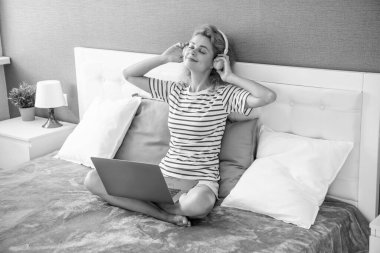 Neşeli kadın kulaklıkla müzik dinliyor. Kadın evde kulaklık takarak müzik dinliyor. Kulaklıklı müzik kadını..