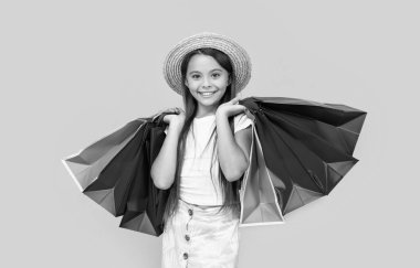 happy teen girl with shopping bags on yellow background.