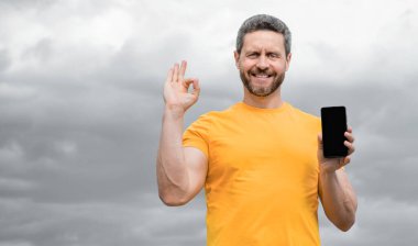 Adam akıllı telefon ekranına kopyalama alanı sunuyor. Tamam.