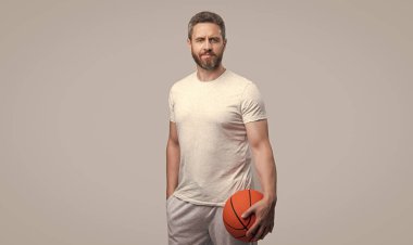 Gri arka planda izole edilmiş olgun atlet basketbolcu. Stüdyoda atlet basketbol oyuncusu. Basketbolcu ve topçunun fotoğrafı. Spor giyim sektöründe basketbol oyuncusu..