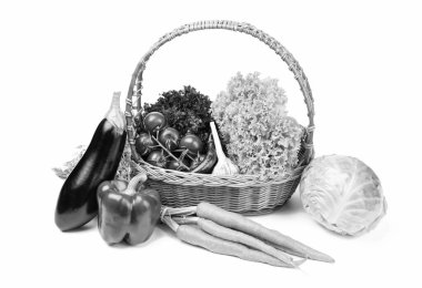 Still-life with fresh vegetables in basket isolated on white.