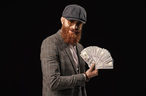 happy rich retro man with money in studio. rich retro man with money on background. photo of rich retro man with money wear peaked cap. rich retro man with money isolated on black.
