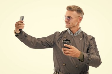 Mutlu gülümseyen iş adamı iş adamı iş telefonuyla selfie çeken iş adamı iş adamı iş adamı iş adamı yönetmeni beyaz, selfie 'de izole edilmiş kahve fincanı stüdyosu..