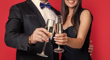 Seçici odaklı çift resmi smokin giyer. Şerefe konsepti. Beyaz arka planda izole edilmiş resmi smokinli çiftin tezahüratları. Resmi smokinli çift. Resmi smokinli çiftin tezahüratlı stüdyo fotoğrafları..