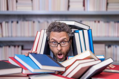 Bilgi günü. Okul sınavına hazırlan. Çok çalışan milenyum öğrencisi kitap okuyor. Kitapçıda ya da okul kütüphanesinde kitap okuyan çok çalışan bir öğrenci. Okulda öğretmenim kitapla birlikte. eğitim kavramı.