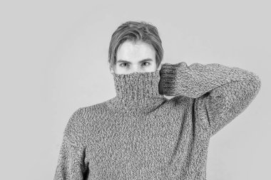 Soğuk kışta bir adam mavi arka planda izole edilmiş. Stüdyoda kışlık süveter içinde üşüyen bir adam. Adam üşüyor ve ısınıyor. Erkekler soğuk kazak giyer..