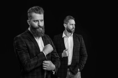 Resmi giyinen erkekler siyah arka planda izole edilmiş, seçici bir odak noktası var. Resmi giysili sakallı adamlar. Forma giyen zarif erkekler. Stüdyoda iki tane resmi kıyafet ceketli adam var..