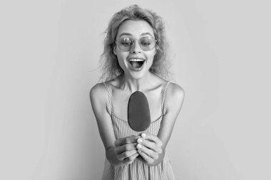 Yazın dondurmalı bir kadının seçici odak fotoğrafı. Dondurmalı kadın sarıda izole edilmiş. Stüdyoda dondurmalı kadın. Arkaplanda dondurma olan kadın..