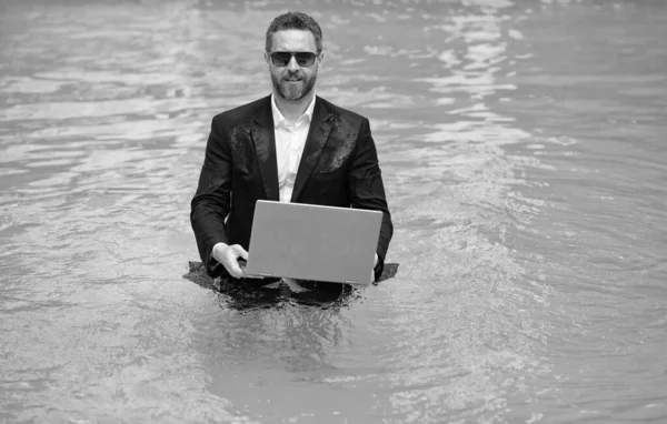 business man working remote with laptop, copy space. photo of business man working remote in summer pool. business man working remote online. business man working remote in swimming pool.